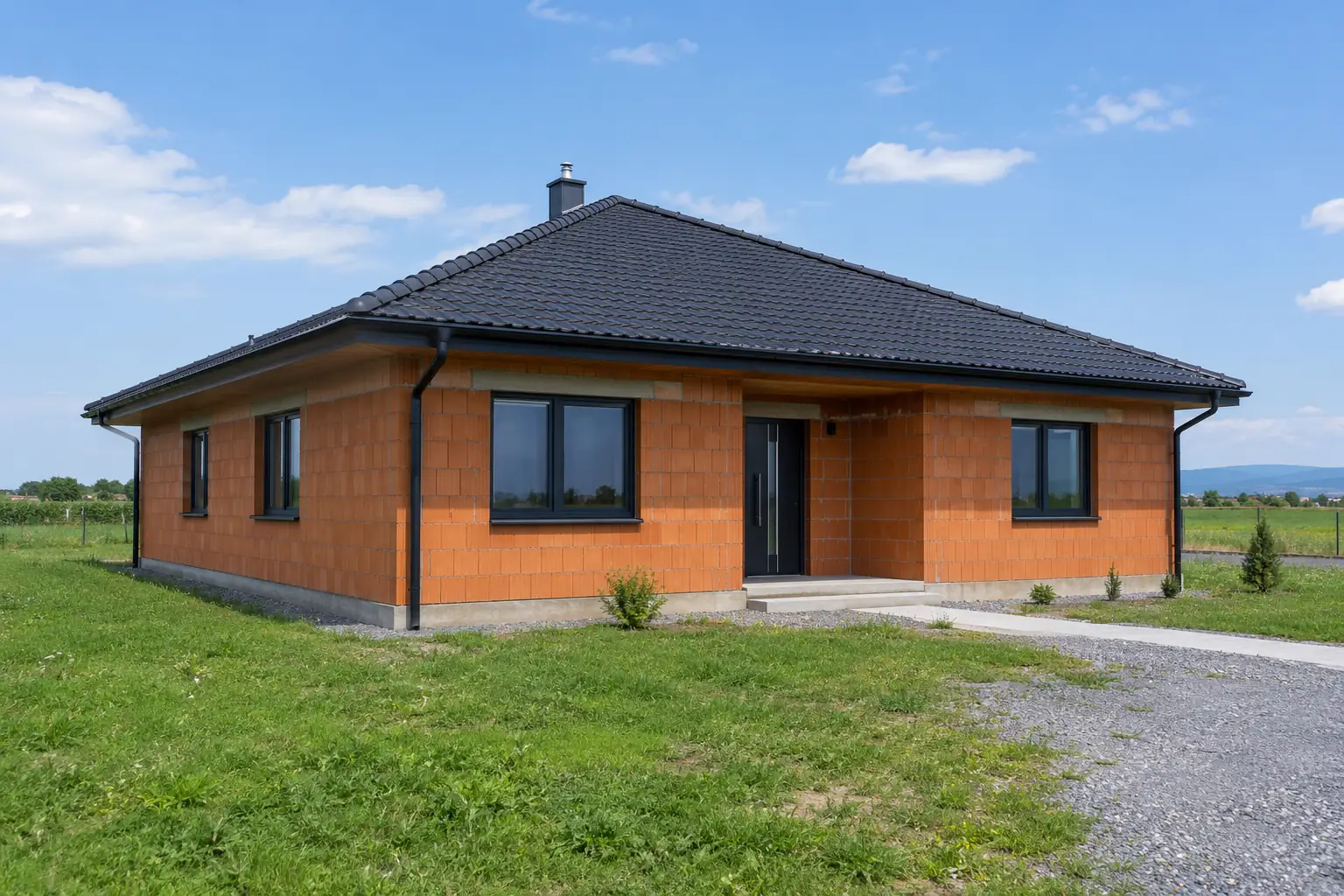 Ilustrácia: hotový bungalov s tmavou škridlou, žľabmi a zvodmi